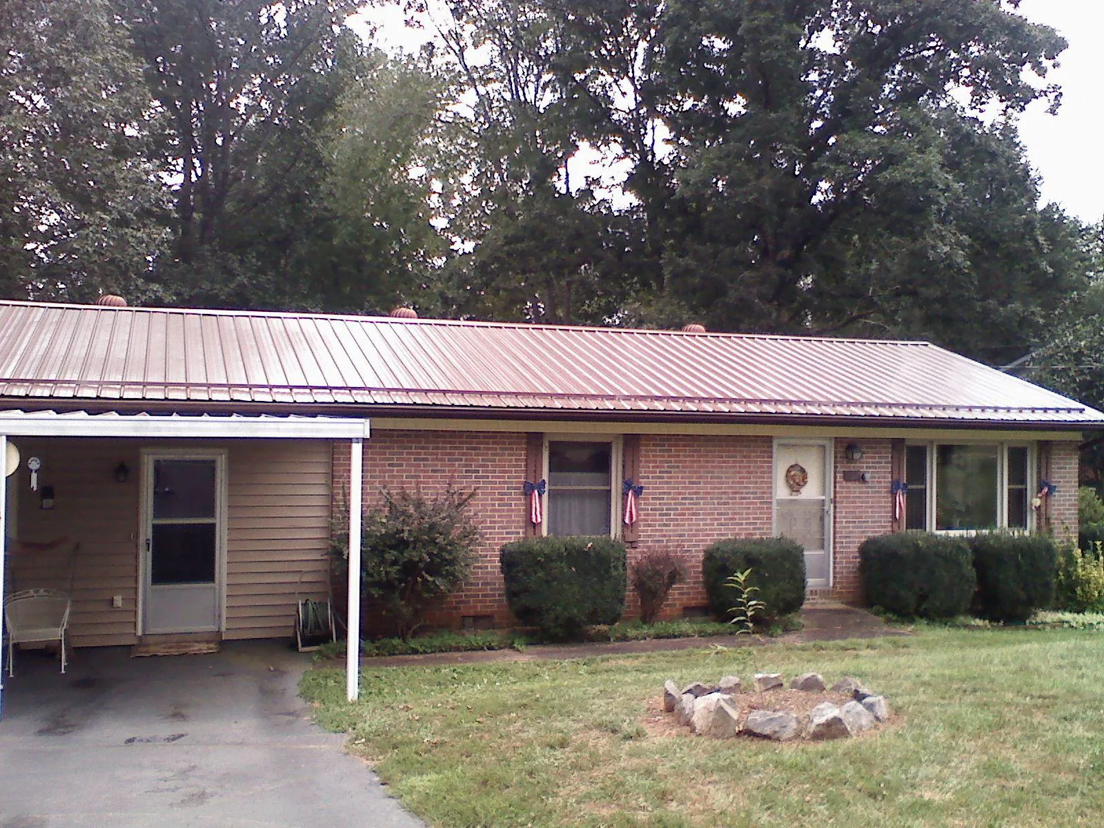 Bronze metal roof and carport on a brick ranch home — Roof Repair work by our crew in Elwood